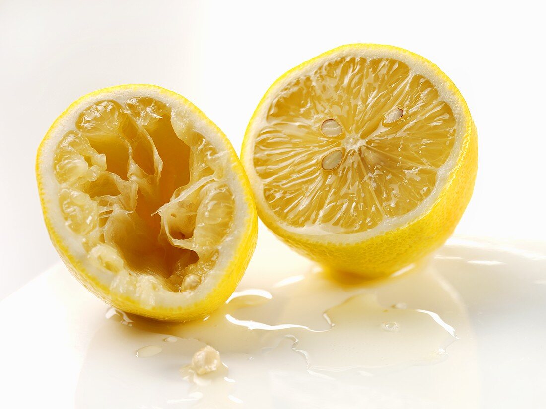Two lemon halves, one squeezed