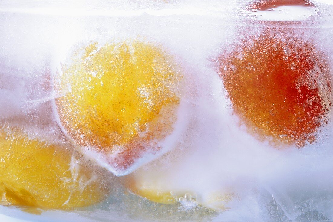 Gefrorene Pfirsiche in einem Eisblock