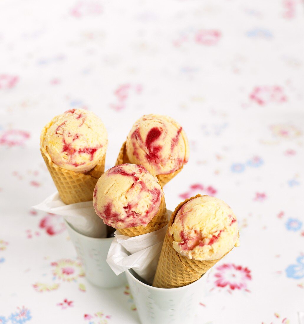 Scoops of vanilla and raspberry ice cream in cones