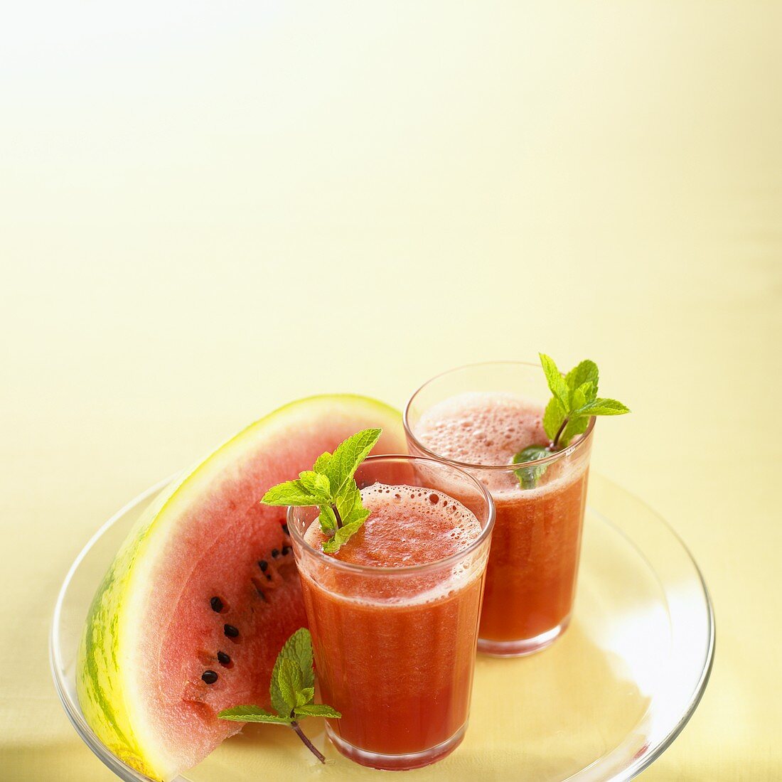 Watermelon juice in juice glasses with wedge of melon