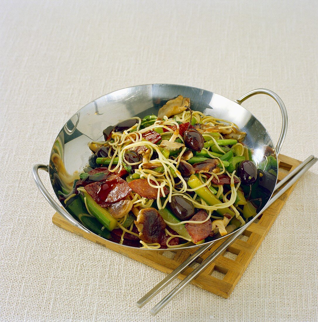 Sausages, noodles and vegetables cooked in wok