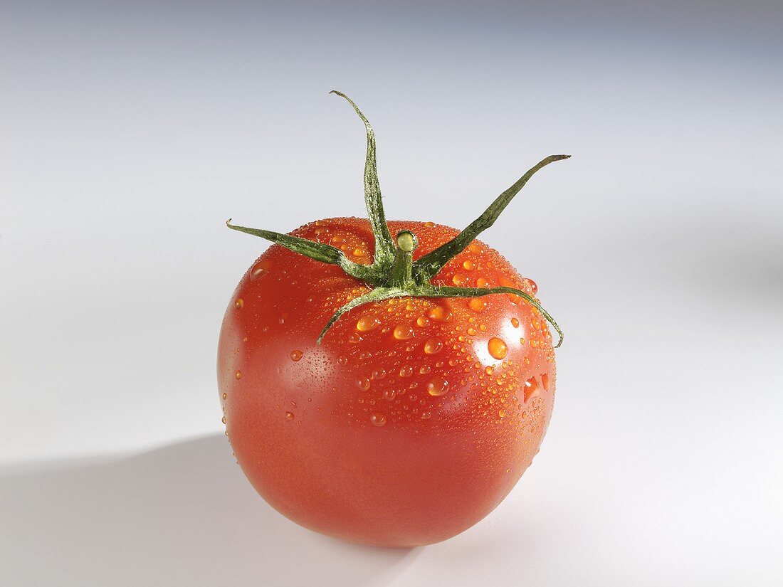 A tomato with drops of water