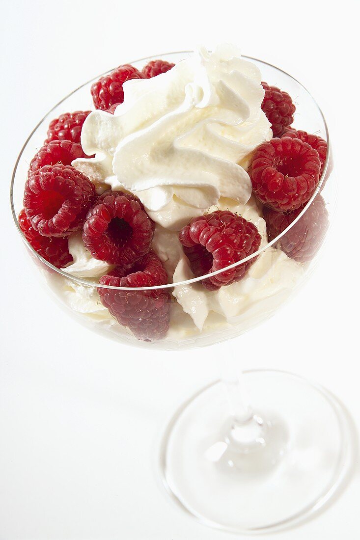 Raspberries with whipped cream in dessert bowl
