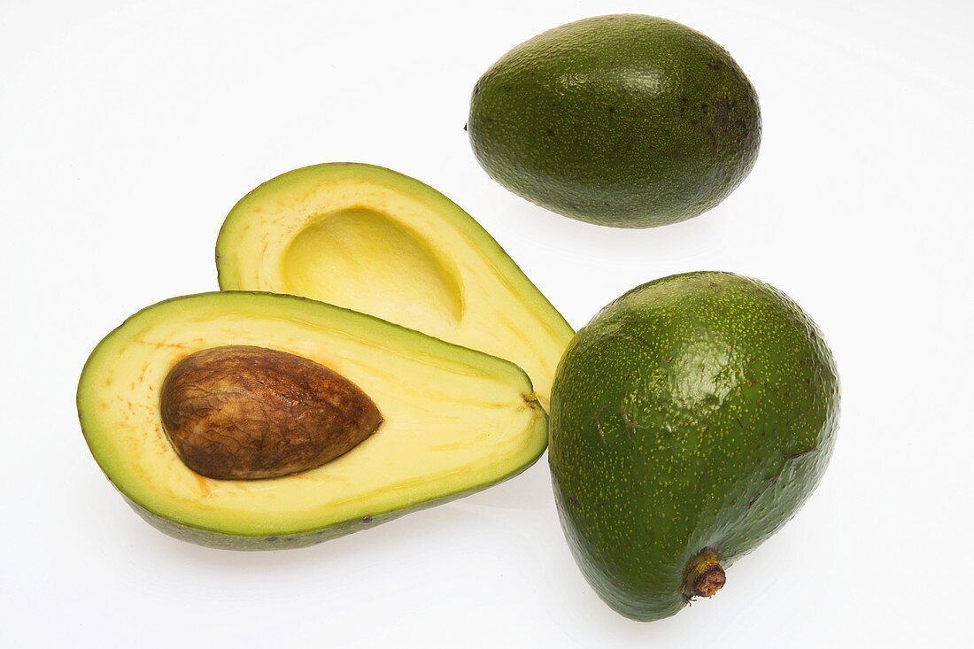 Three avocados, one halved