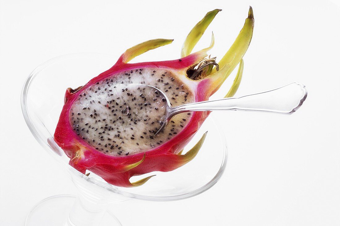 Half a pitahaya in glass bowl with teaspoon