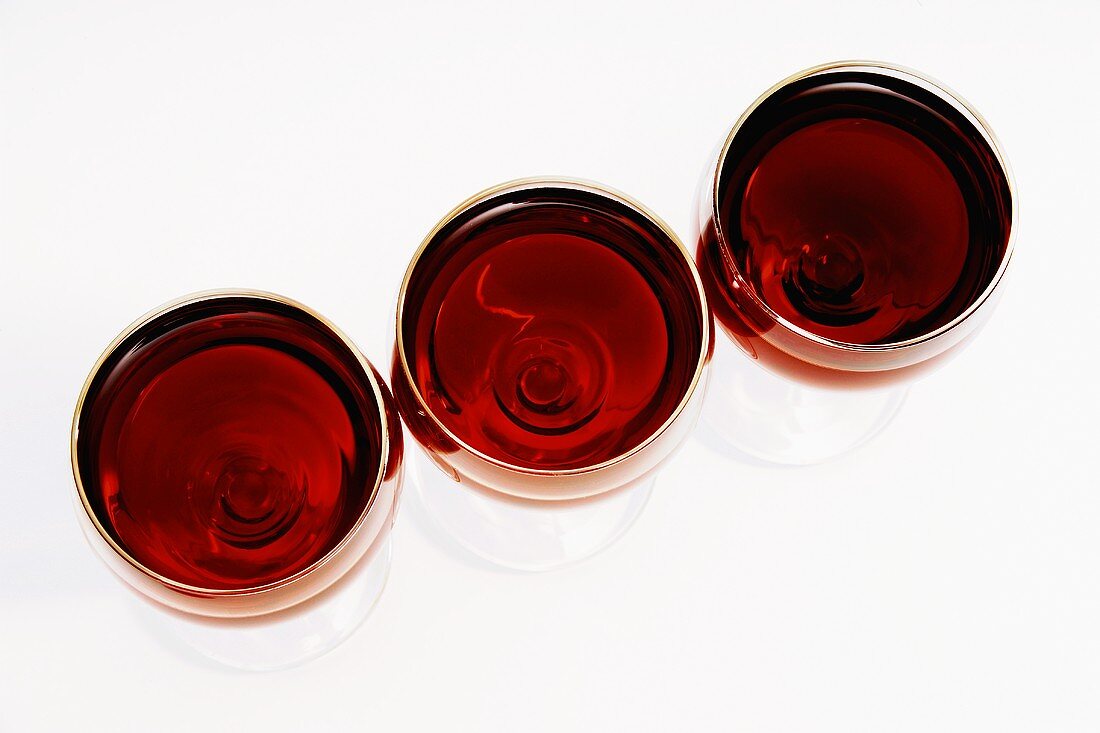 Drei gefüllte Rotweingläser