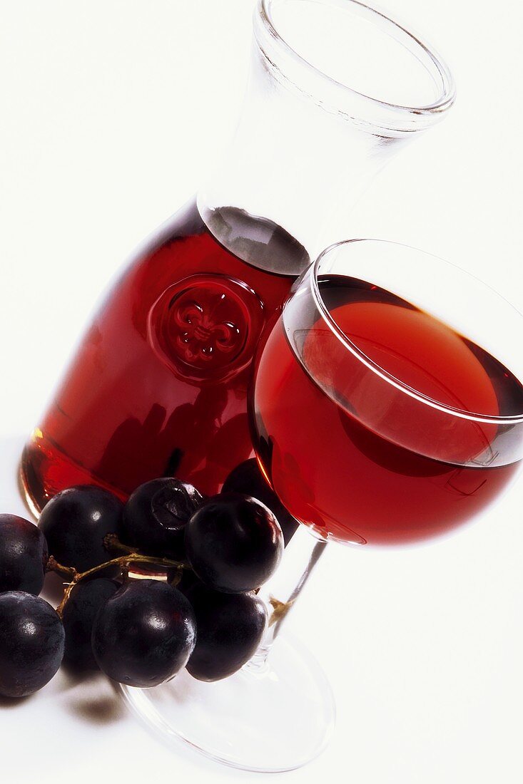 Rotweinstillleben mit Karaffe, Glas und Trauben