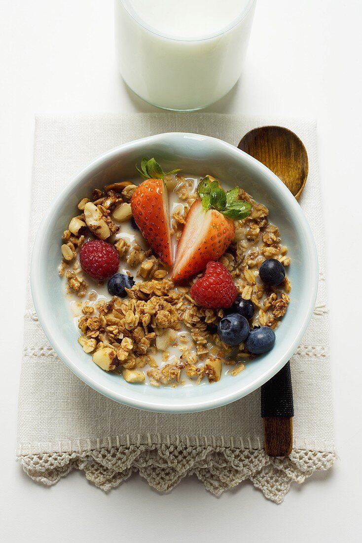 Crunchy muesli with berries and milk in cereal bowl