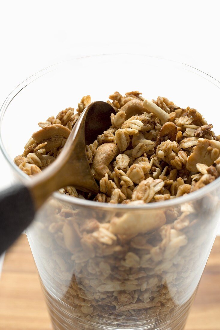 Knuspermüsli in einem Glas mit Holzlöffel