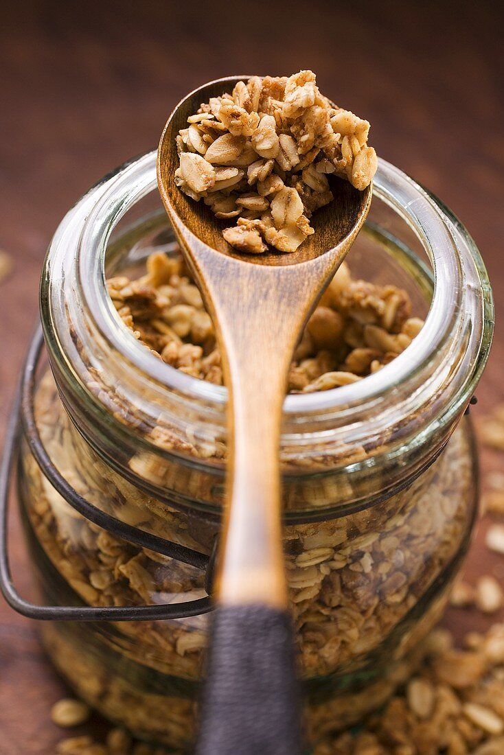 Crunchy muesli in a jar and on a wooden spoon