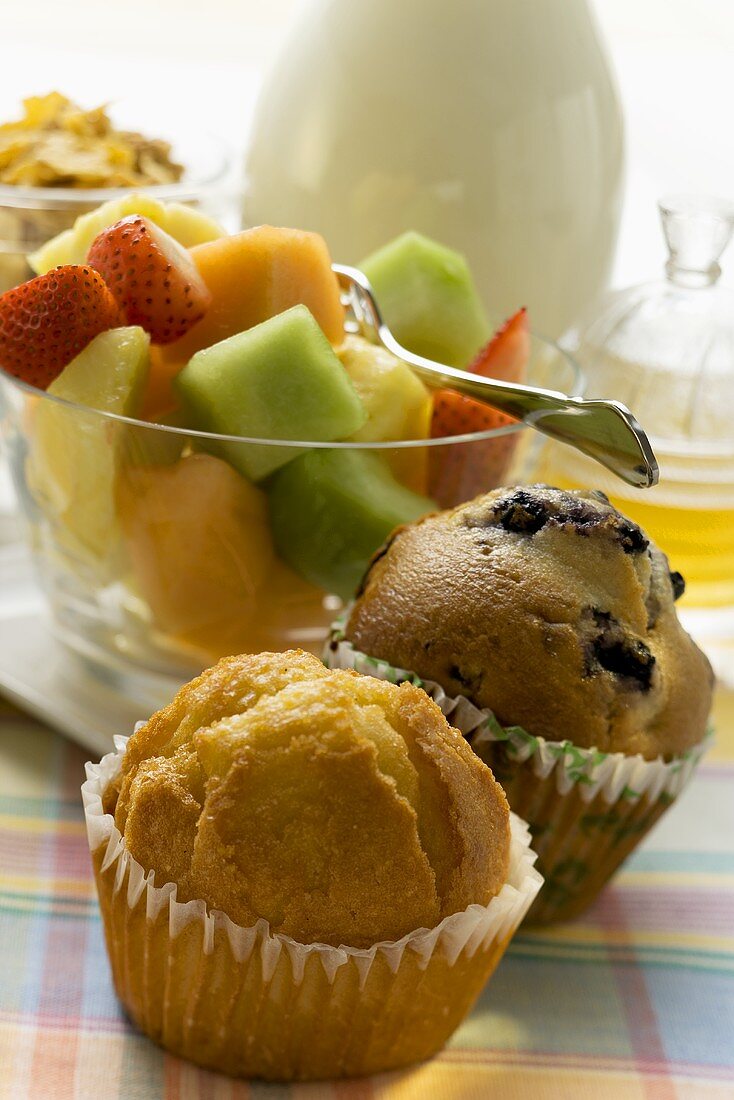 Brunch mit Muffins, Obstsalat, Cerealien und Honig