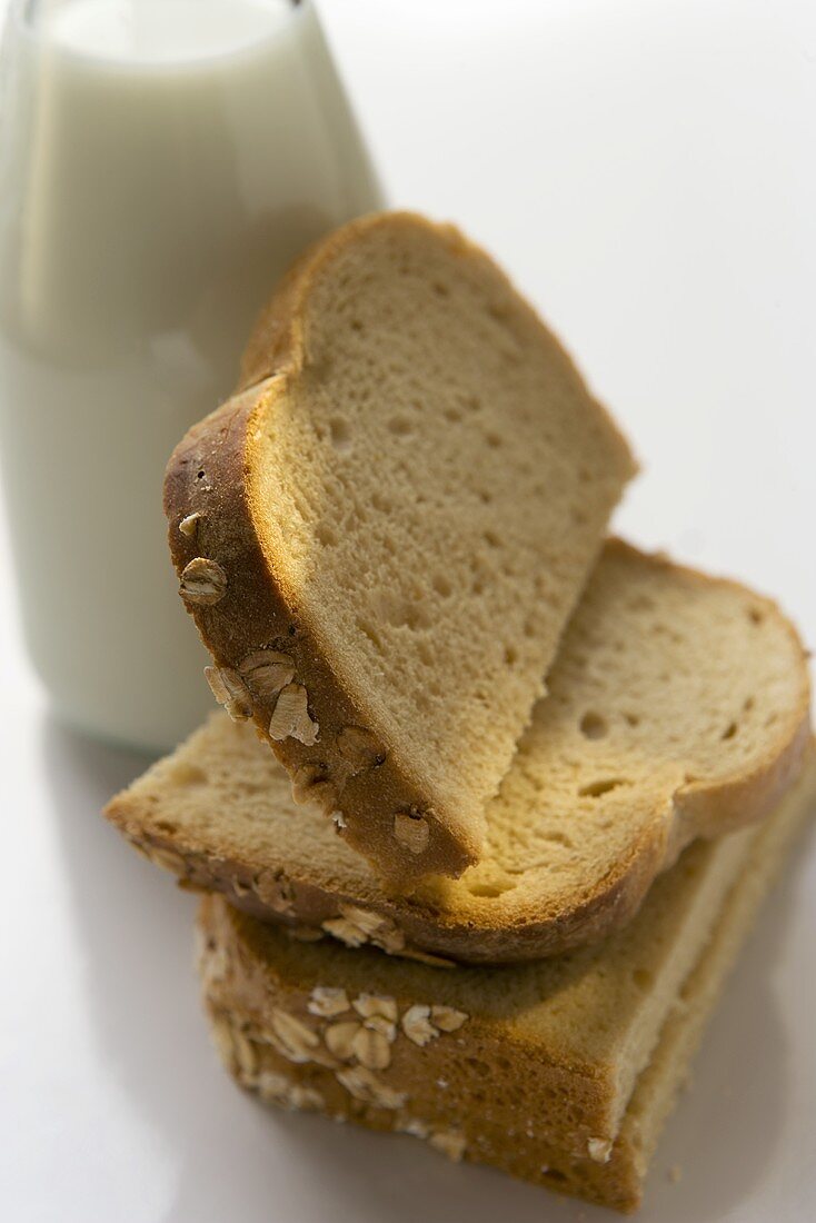 Slices of bread leaning against a milk bottle