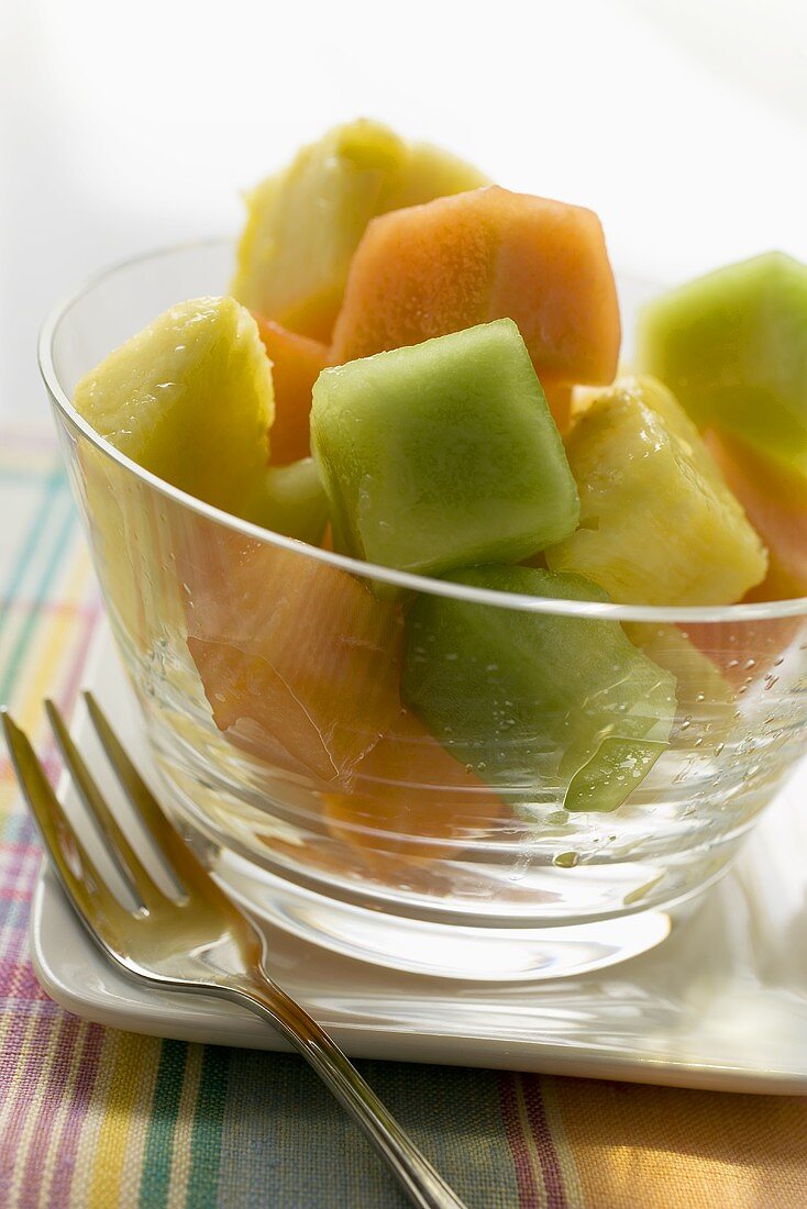 Pineapple and melon fruit salad in a glass bowl