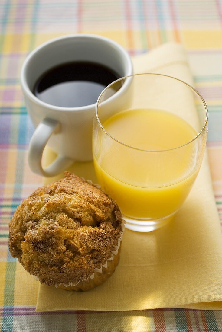 Kaffee, Orangensaft und Muffin auf einer Stoffserviette