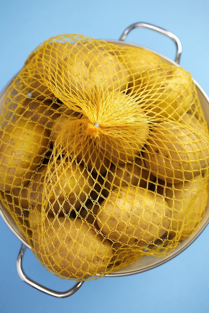 Potatoes in packaging in a colander