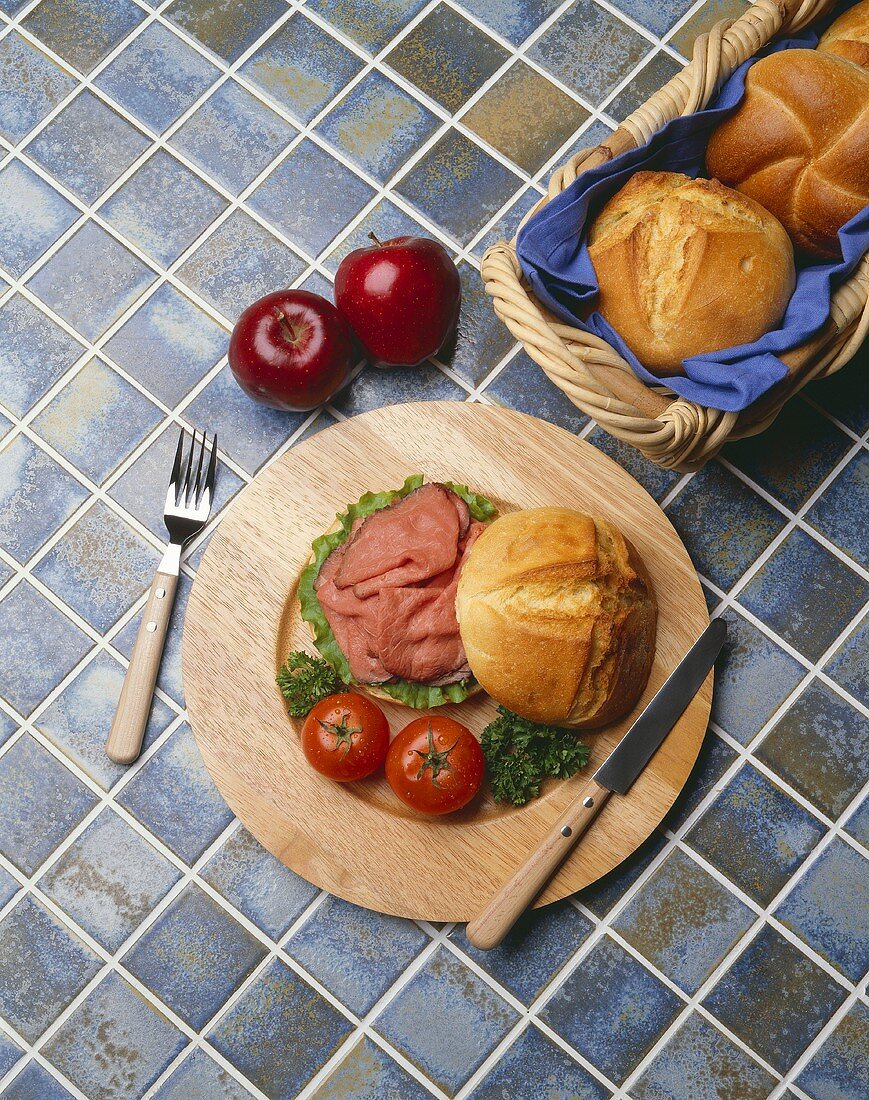 Roast Beef Sandwich with Tomatoes on a Round Wooden Plate
