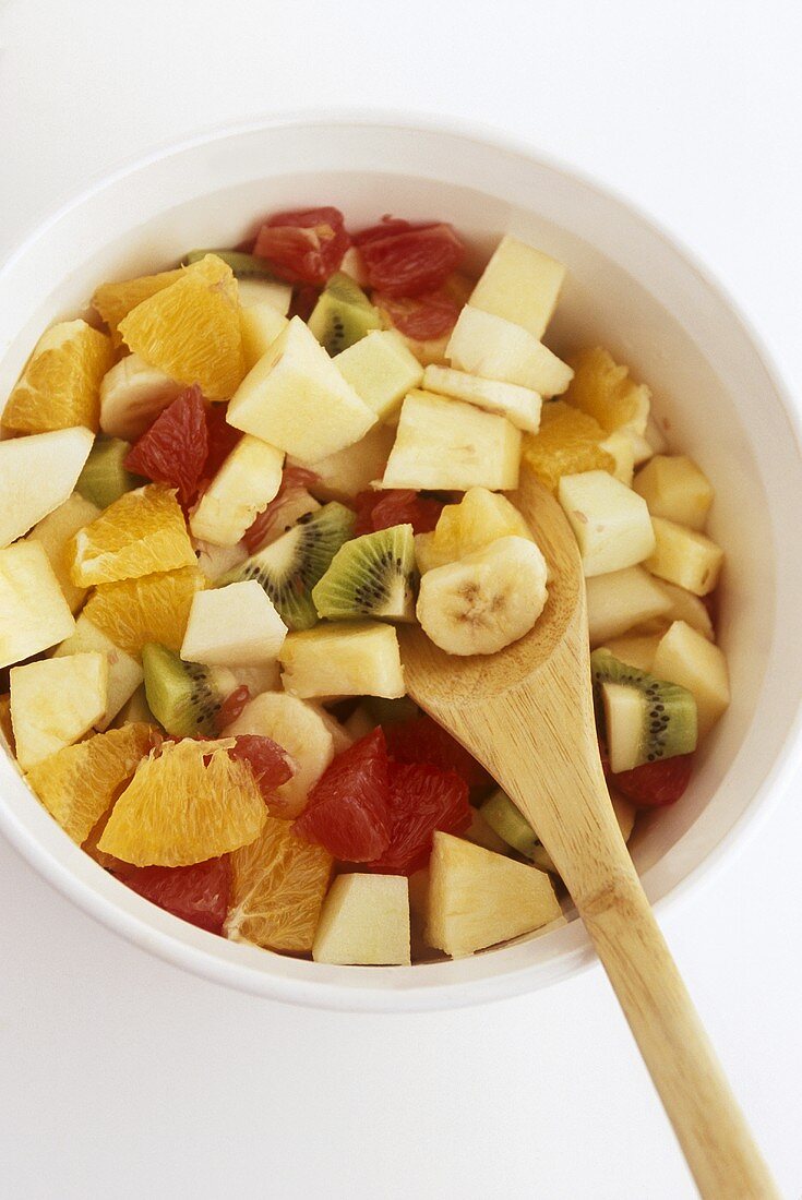 Bowl of Fruit Salad with Wooden Spoon; From Above