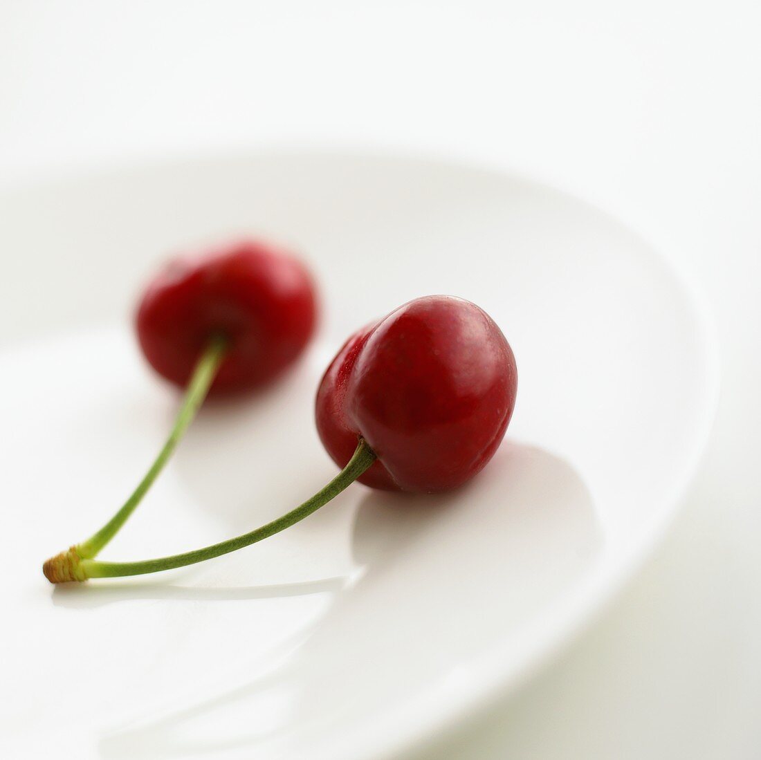 Two cherries on a plate
