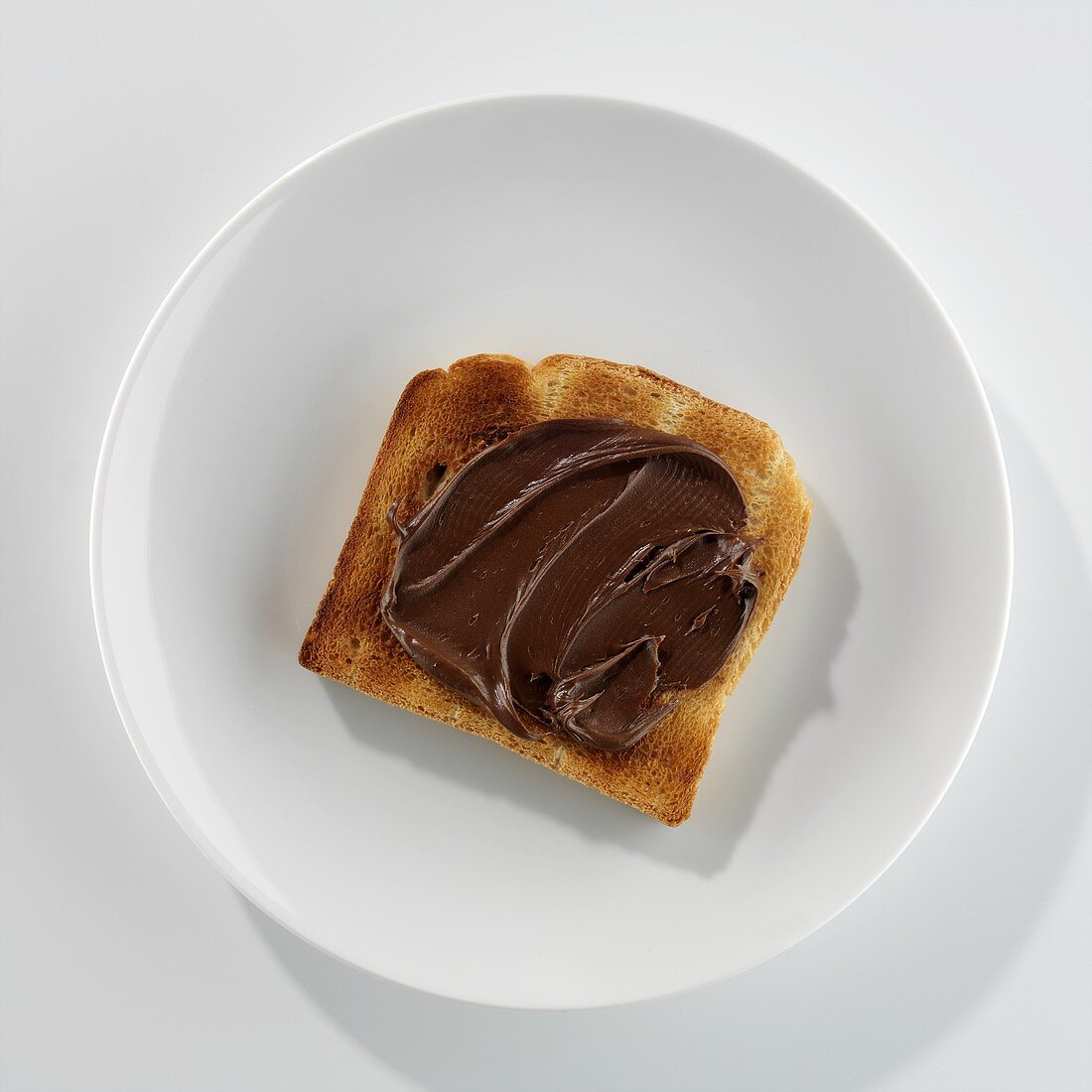Eine Scheibe Toast mit Nutella auf einem Teller