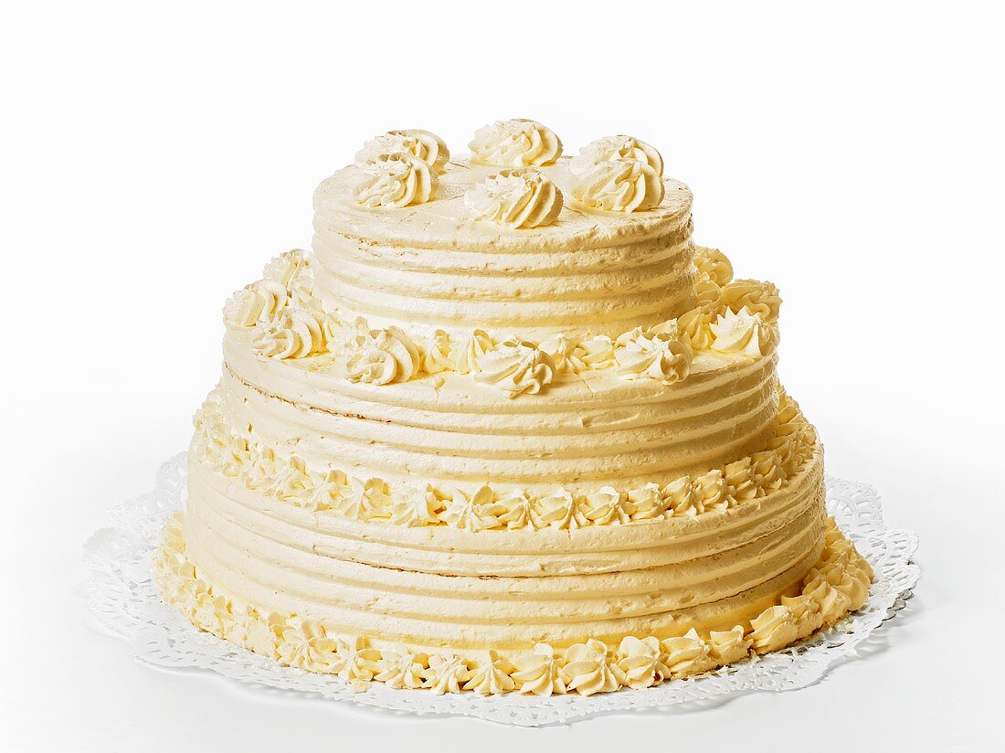 A three-tiered cream cake on white background