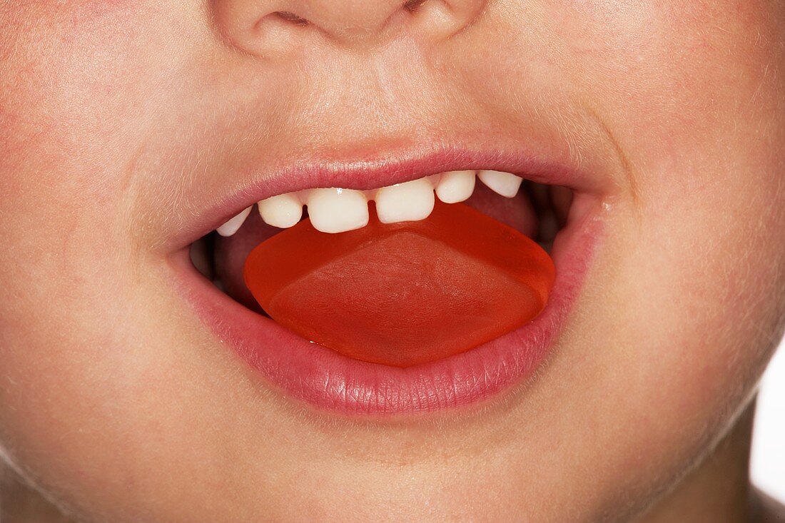 Child eating a red wine gum