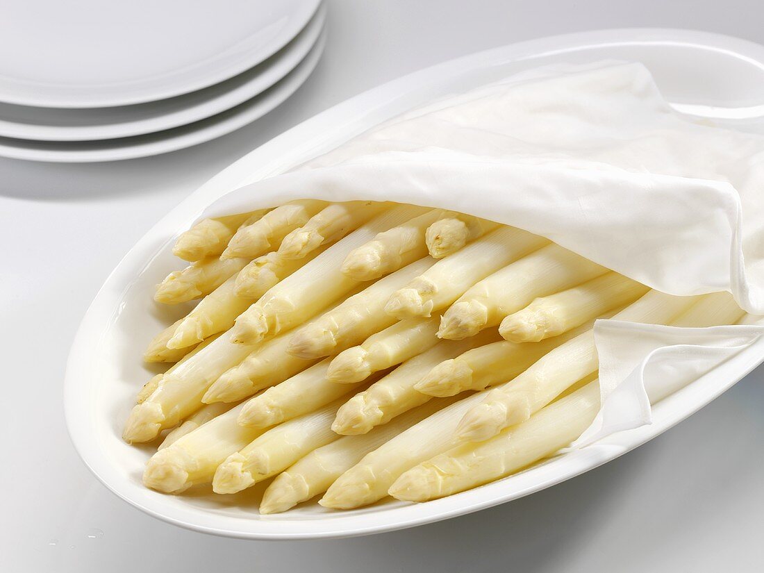 Cooked white asparagus on a platter