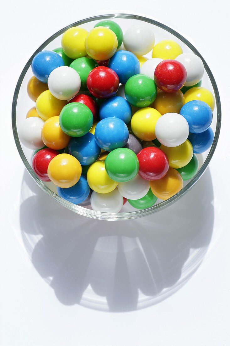 Lots of coloured chewing gum balls in a glass bowl