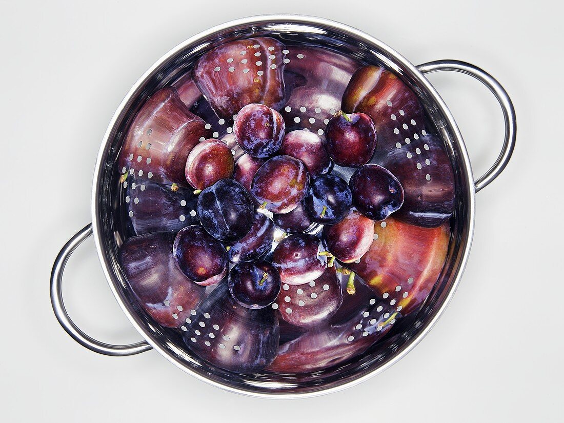 Fresh plums in a colander