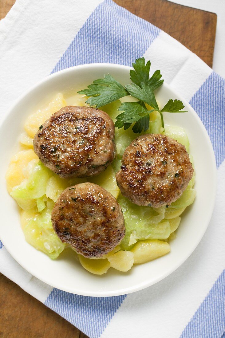 Burgers on potato and cucumber salad