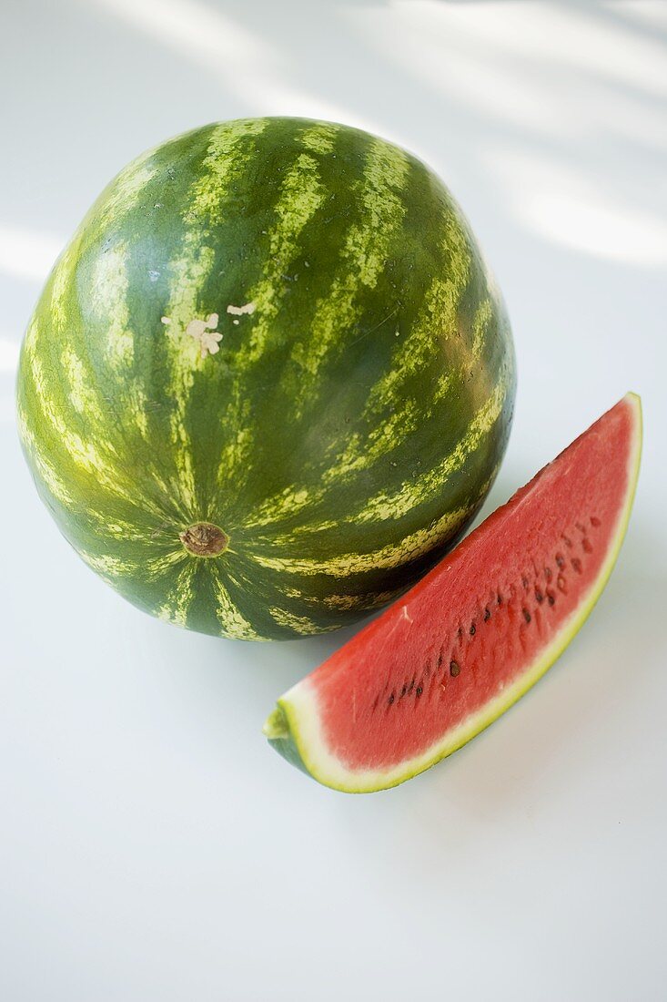A watermelon and a slice of watermelon
