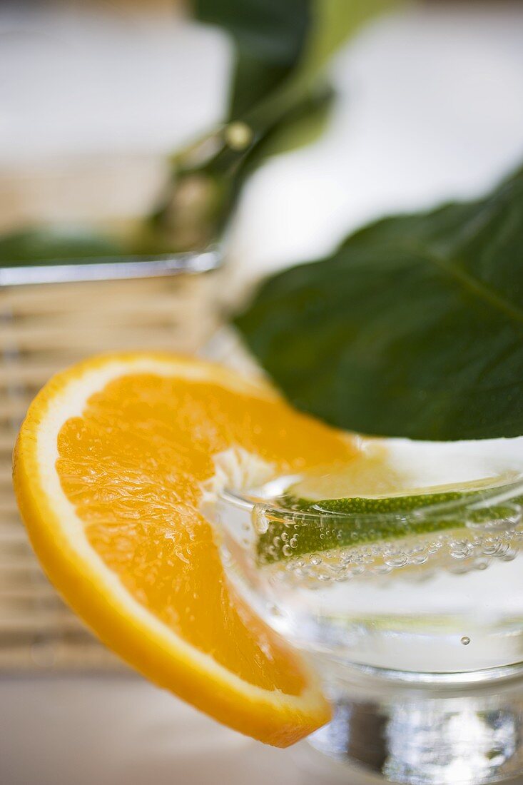 Ein Glas Mineralwasser mit Limetten- und Orangenscheibe