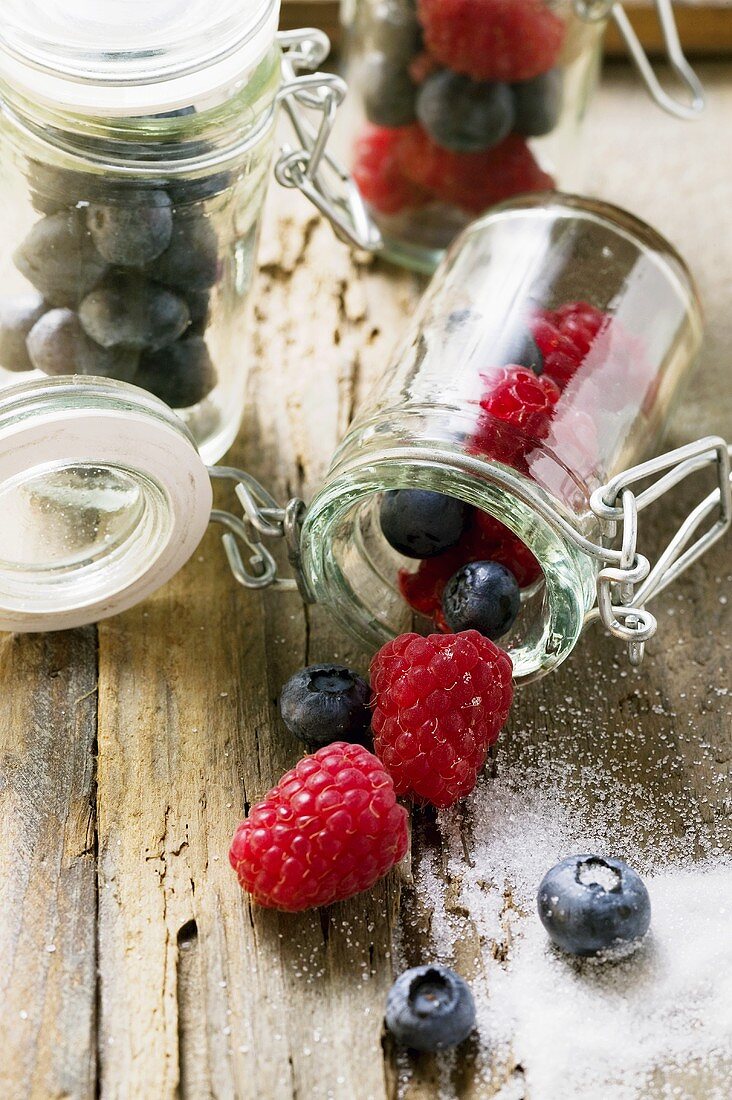 Frische Himbeeren und Heidelbeeren in Einmachgläsern