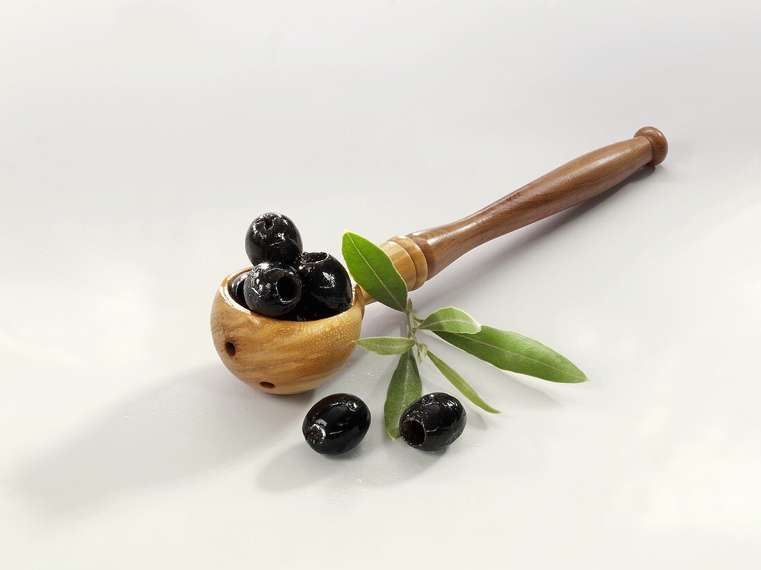 Black olives in a wooden spoon