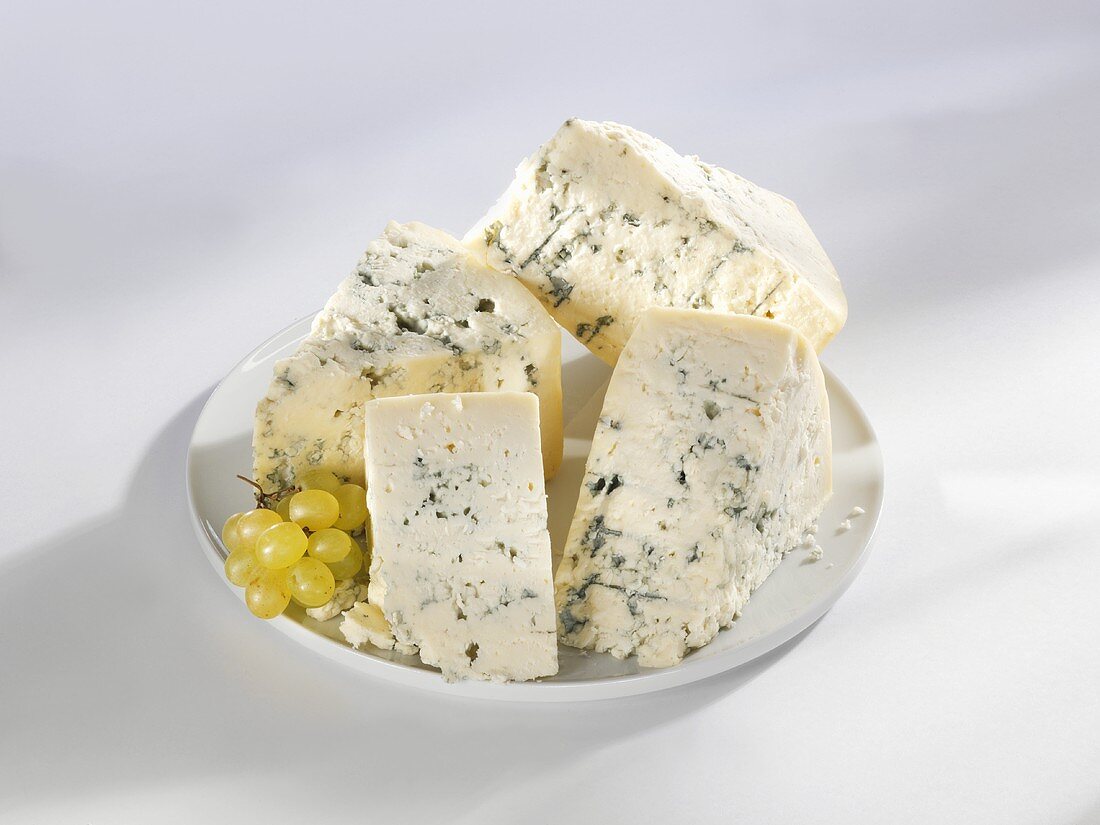 Four wedges of blue cheese on a plate