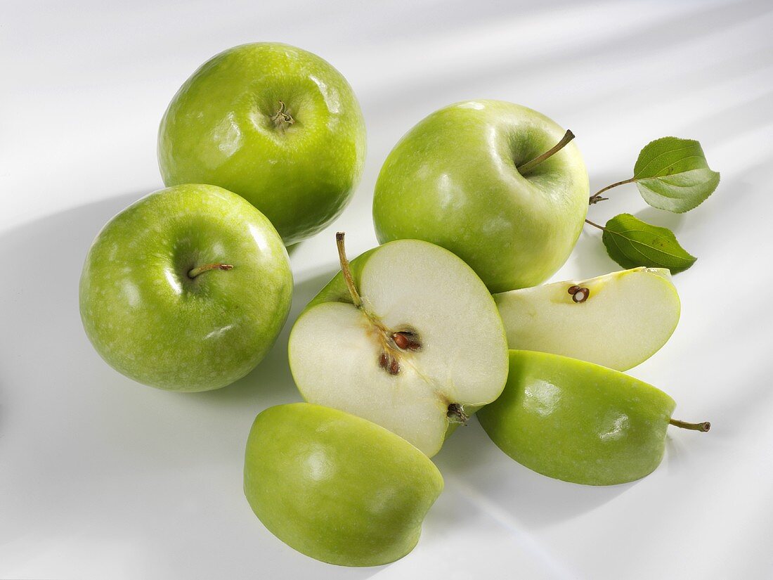 Four 'Granny Smith' apples, one cut into pieces