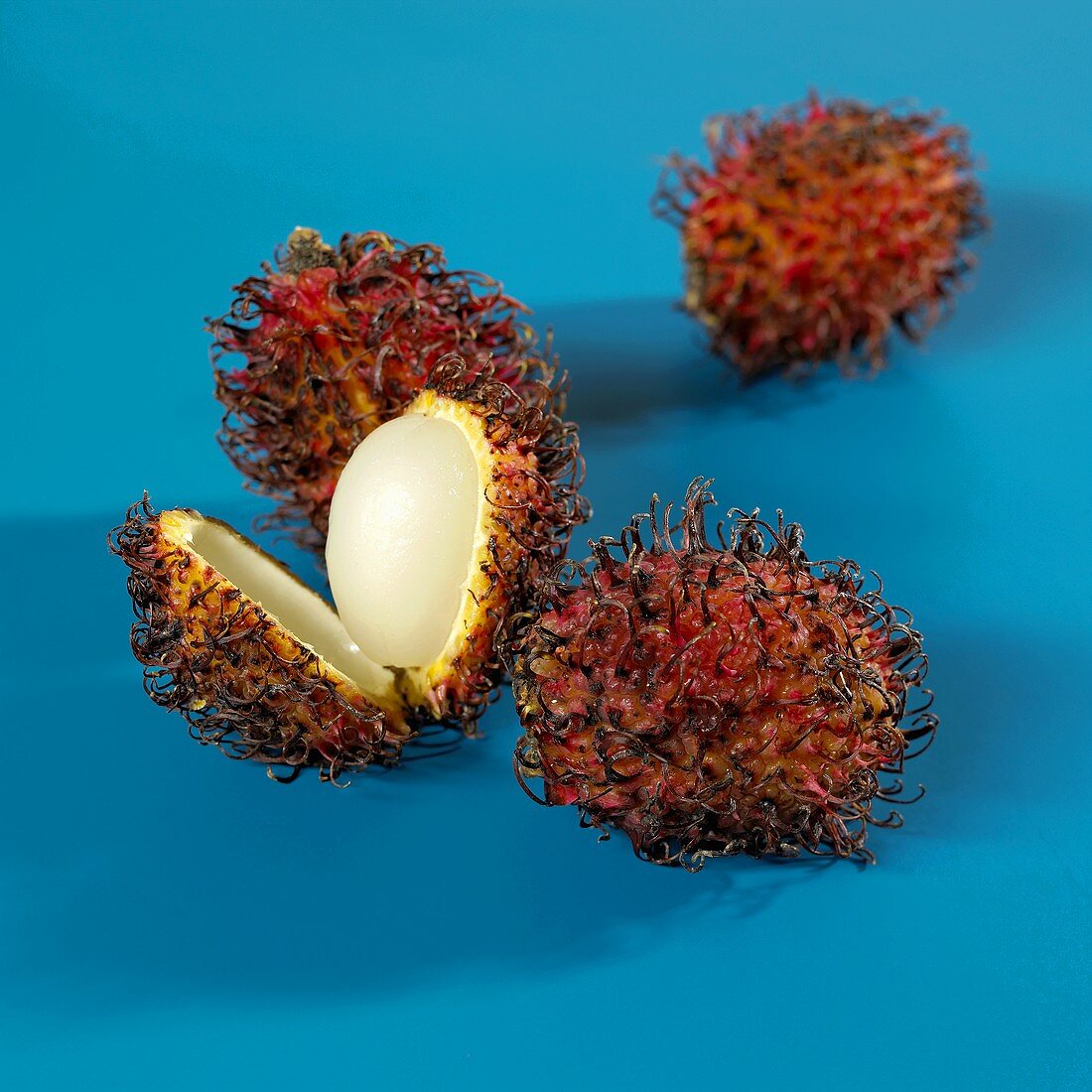 Four rambutans, one half-peeled