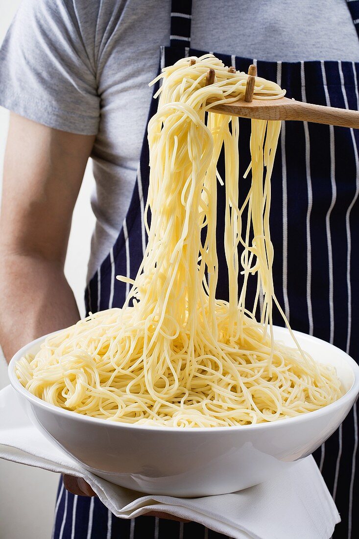 Gekochte Spaghetti in der Schüssel und auf Spaghettiheber