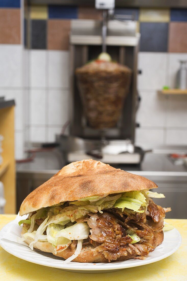 A döner kebab with meat on spit in background