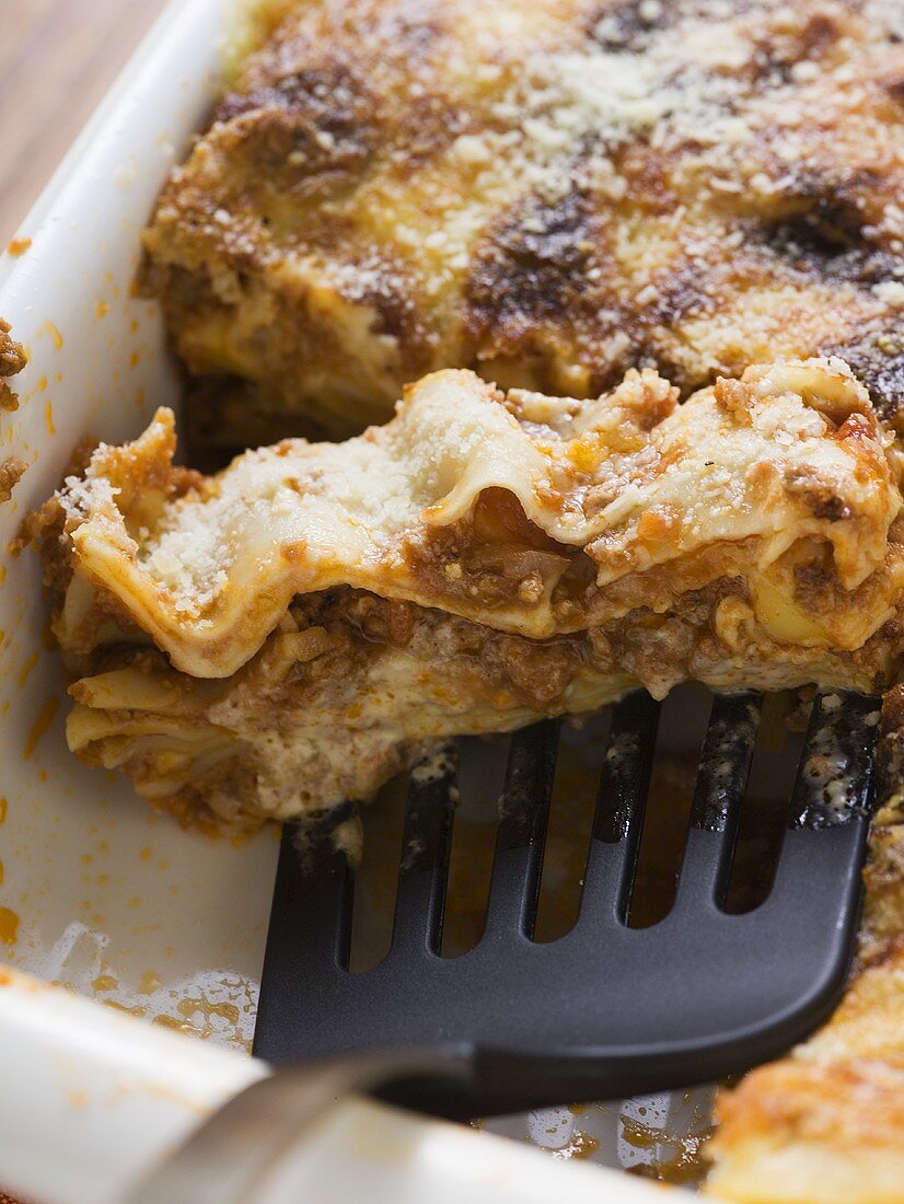 Lasagne in baking dish with spatula