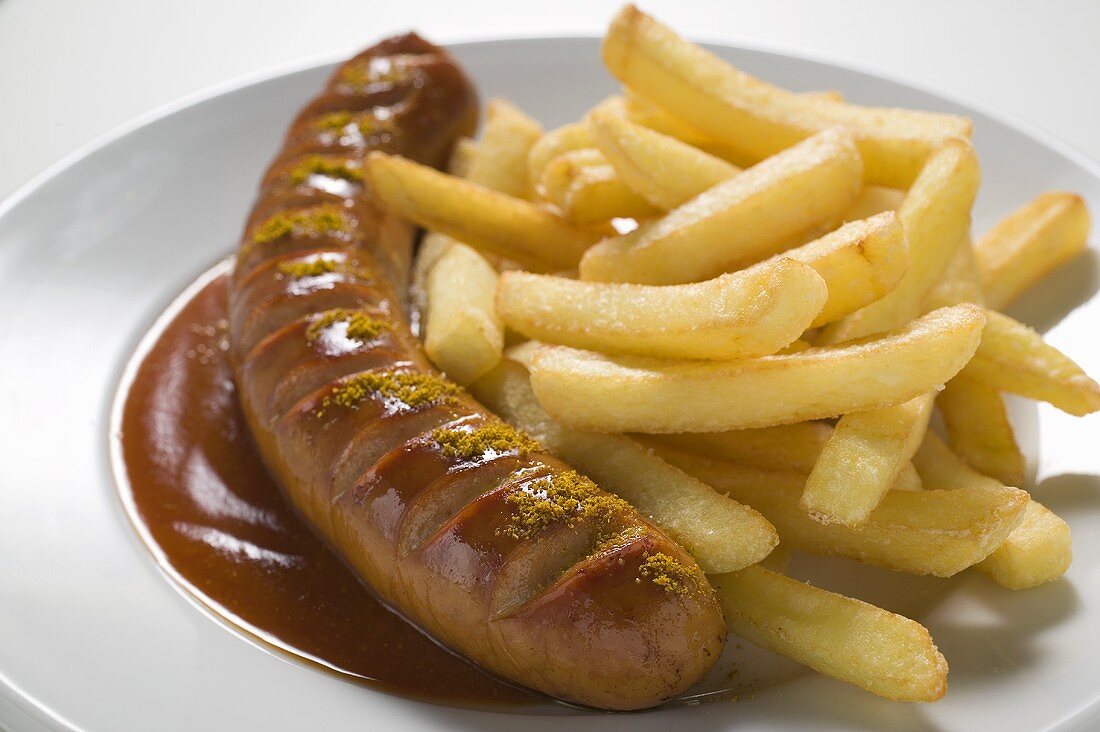 Currywurst mit Pommes Frites & Ketchup auf einem Teller