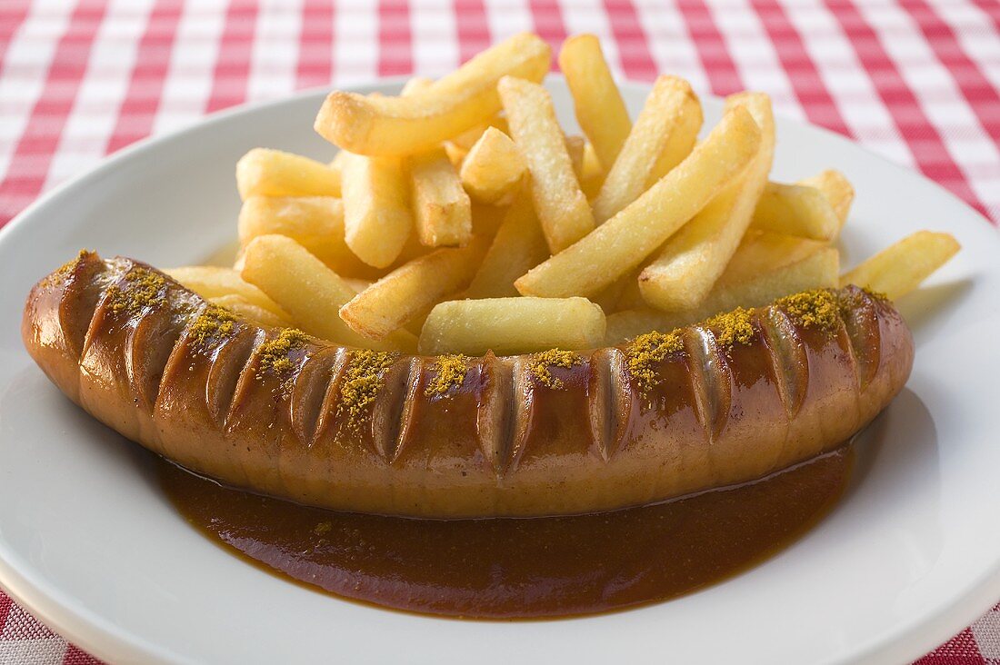Sausage with ketchup, curry powder and chips