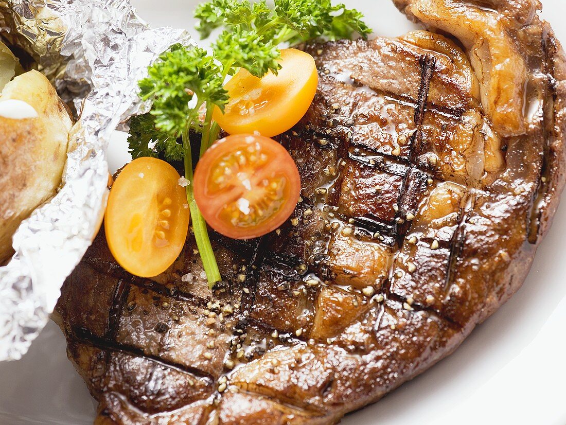 Grilled rump steak with tomatoes and baked potato
