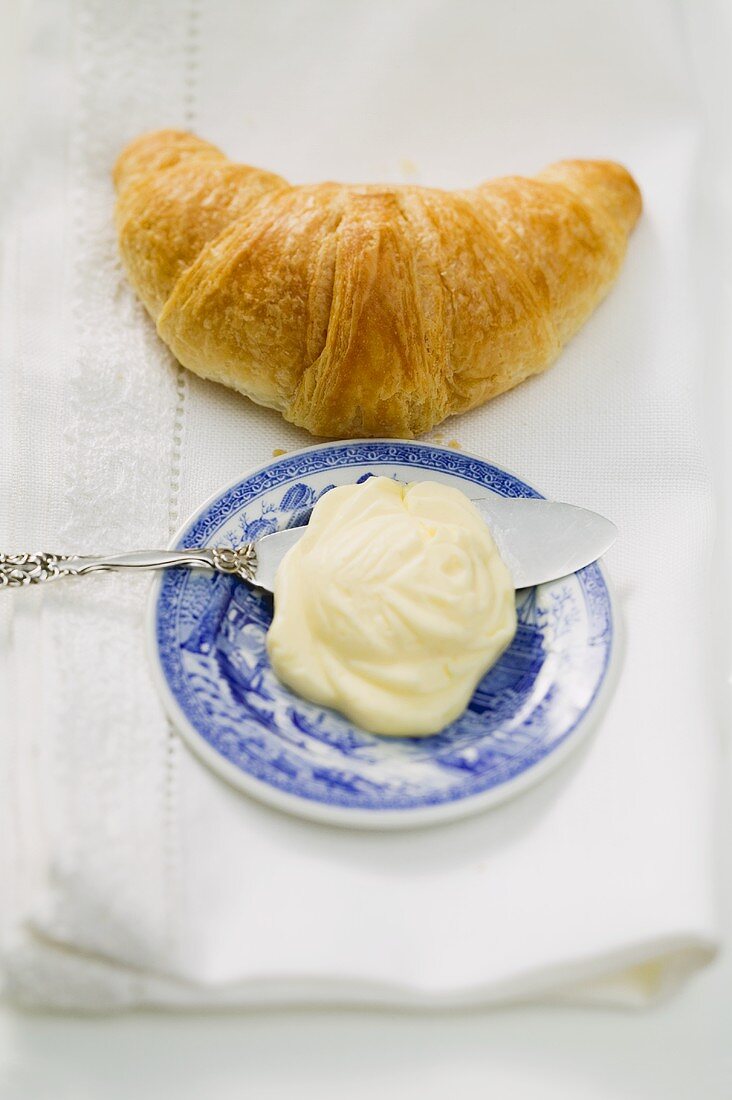 Croissant, butter on plate