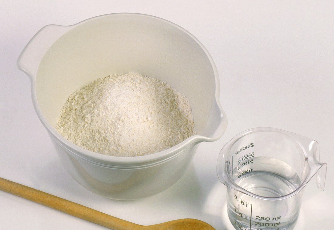 Flour in a bowl and water in a measuring jug
