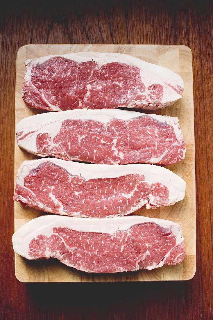 Sirloin steaks on wooden board