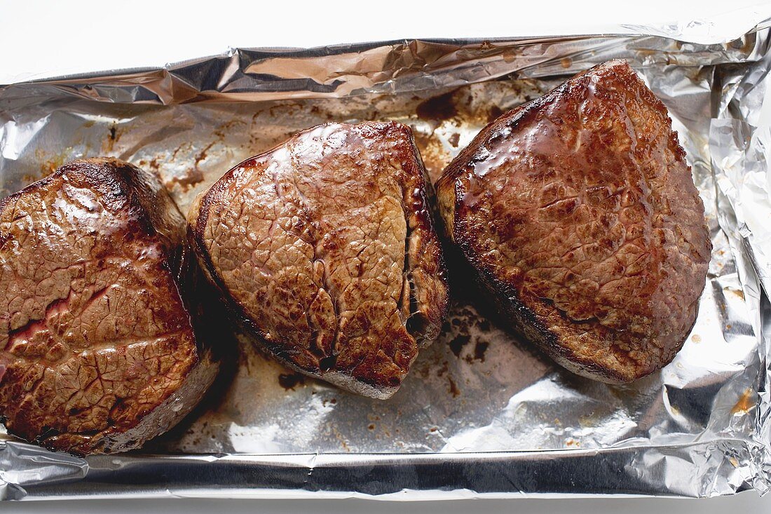 Three fillet steaks on aluminium foil