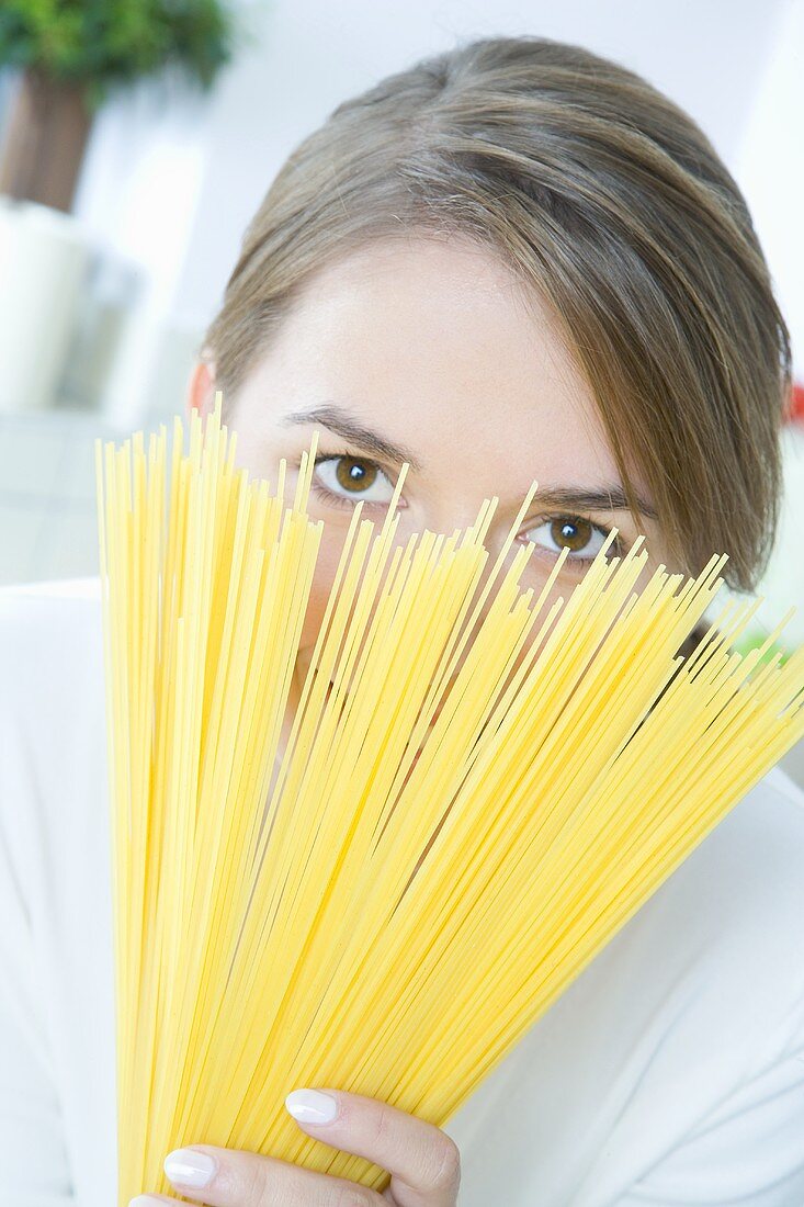 Frau hält Spaghetti in den Händen