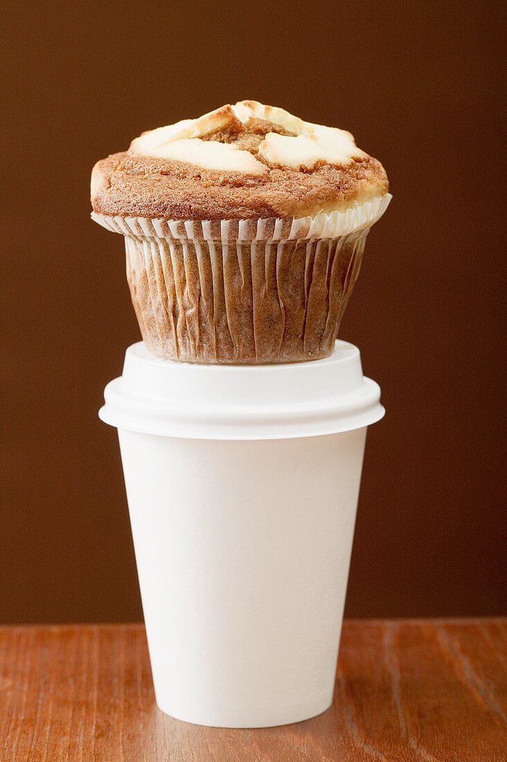 Ein Muffin auf einem Kaffeebecher