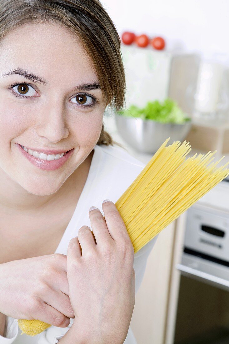 Frau hält einen Bund Spaghetti in den Händen
