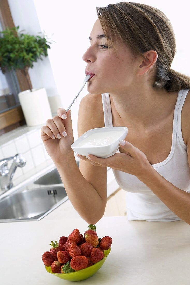 Young woman eating yoghurt